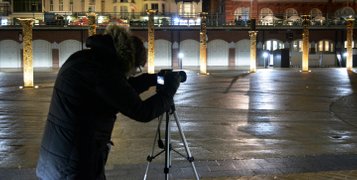 Bright-On-Photography student taking photos with her tripod during the night in front of the illuminated West Pier columns by the i360. Photo by Eva Kalpadaki.